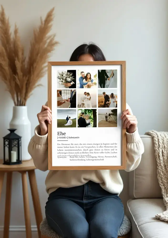 Definitionsposter zur Ehe mit neun Hochzeitsfotos im Holzrahmen vor dem Sofa als Erinnerungsgeschenk zur Hochzeit