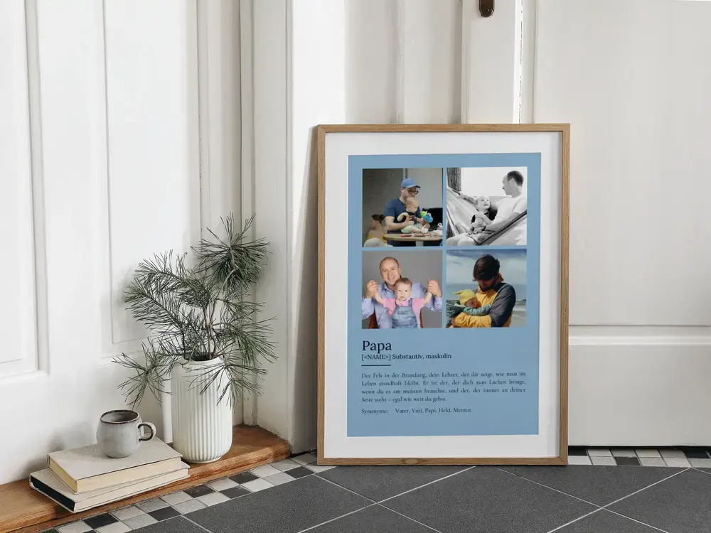Blaues Definitionsposter für Papa mit vier Fotos im Holzrahmen, am Boden neben Büchern und einer Vase