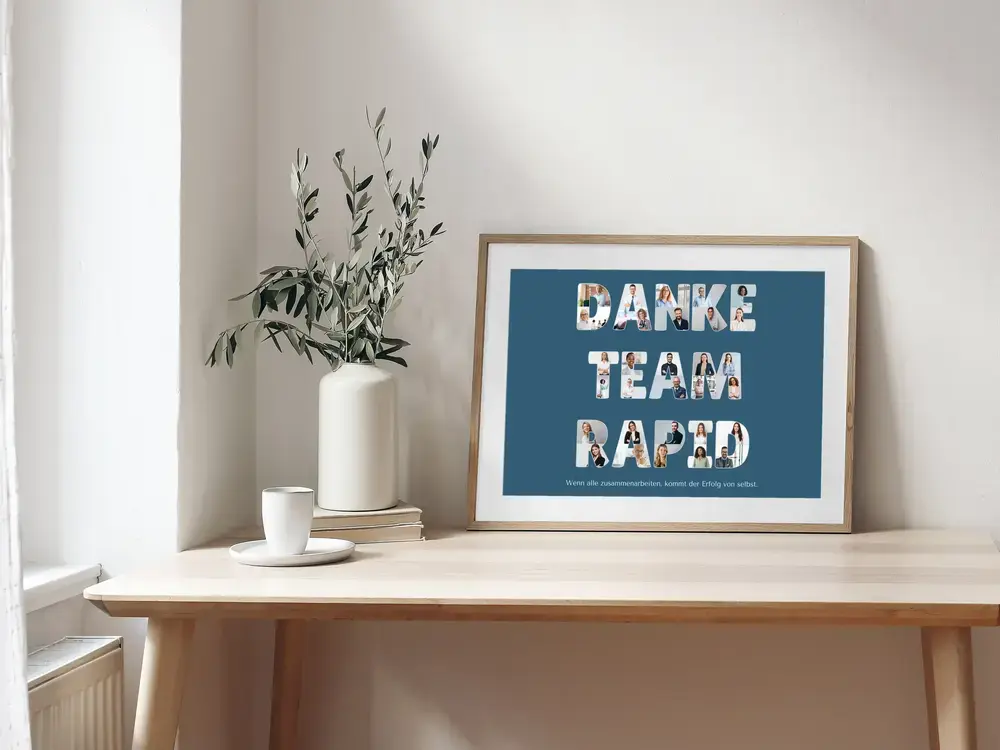 Buchstaben-Fotocollage als Dankeschön fürs Team auf Petrol, im Holzrahmen auf einem Schreibtisch neben einer Vase
