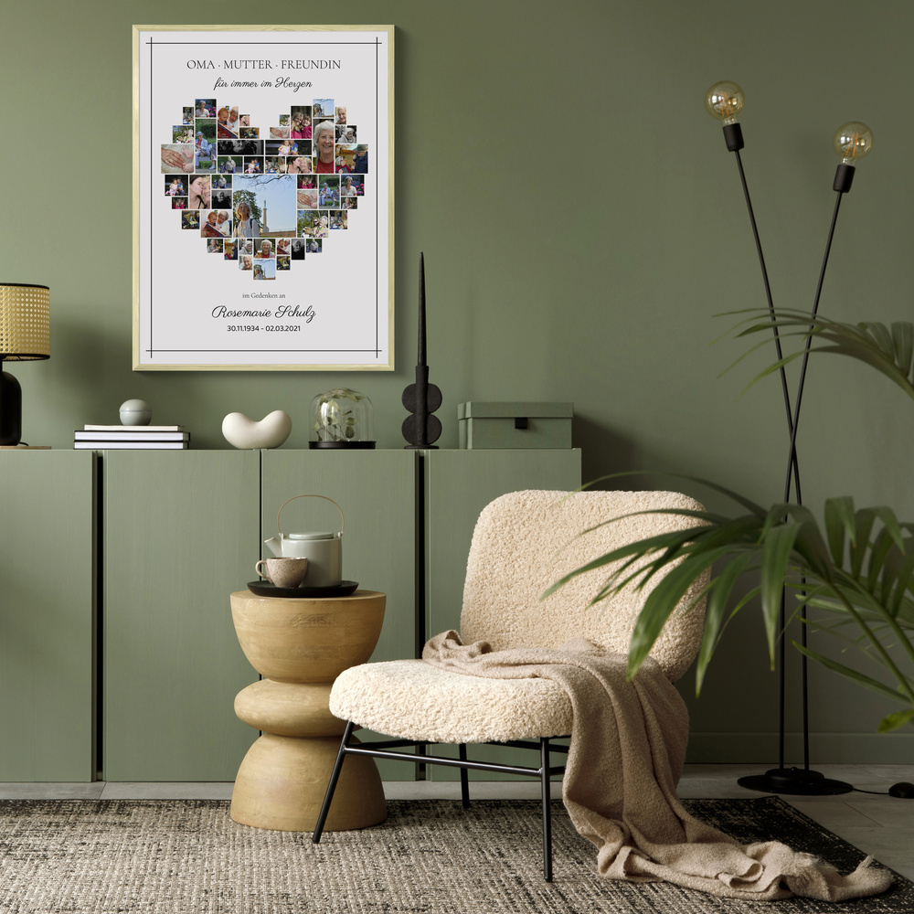 Herzförmige Gedenkcollage im hellen Rahmen an grüner Wohnzimmerwand über einem Sideboard