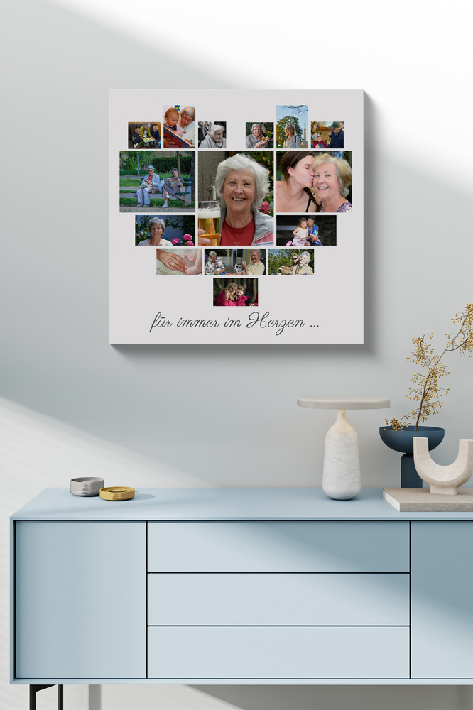 Fotocollage in Herzform mit Gedenktext auf Leinwand über einer hellblauen Kommode mit Vasen